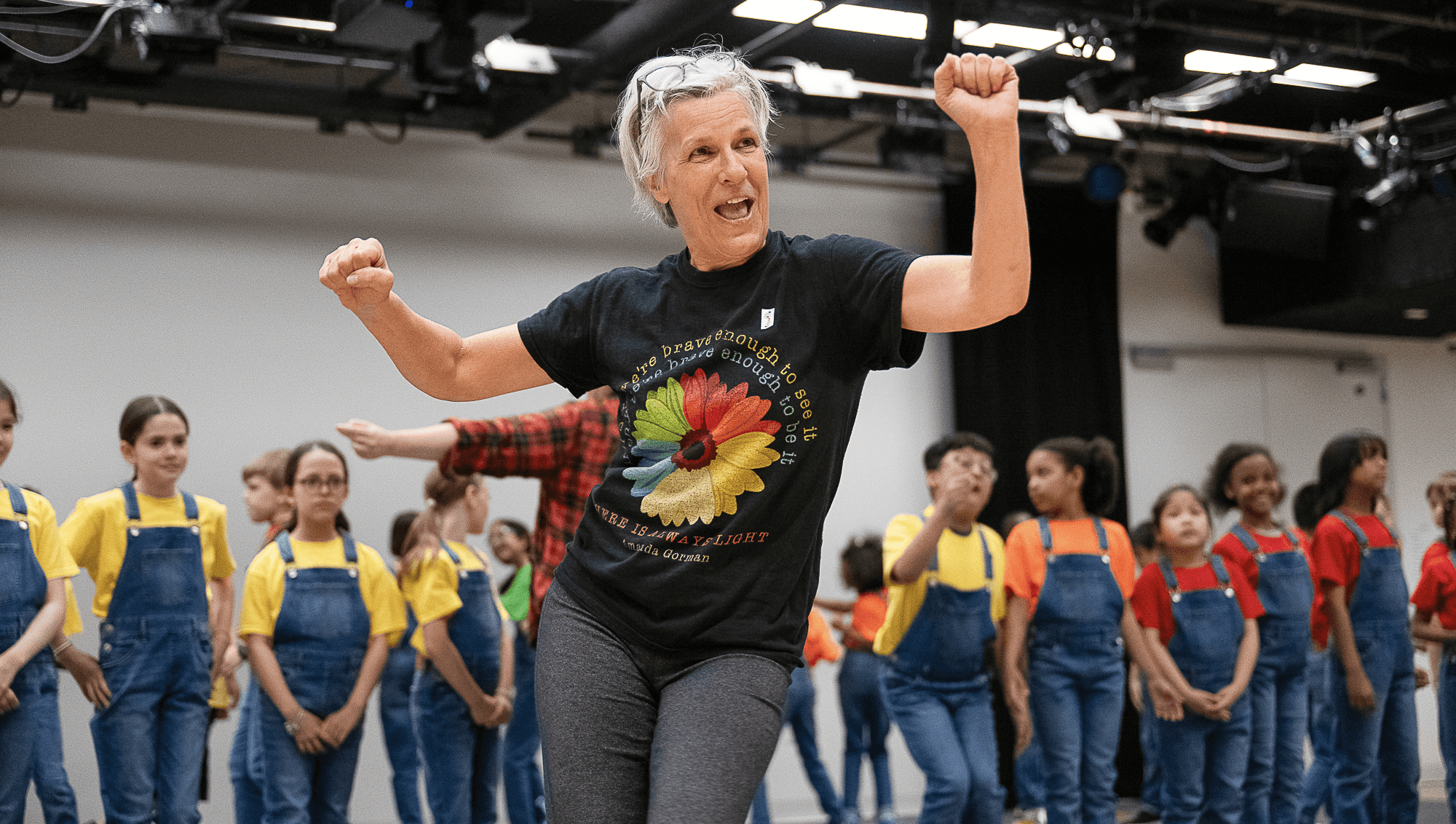 NDI Artistic Director Kay Gayner demonstrates movement to a group of children. Photo by Christopher Duggan