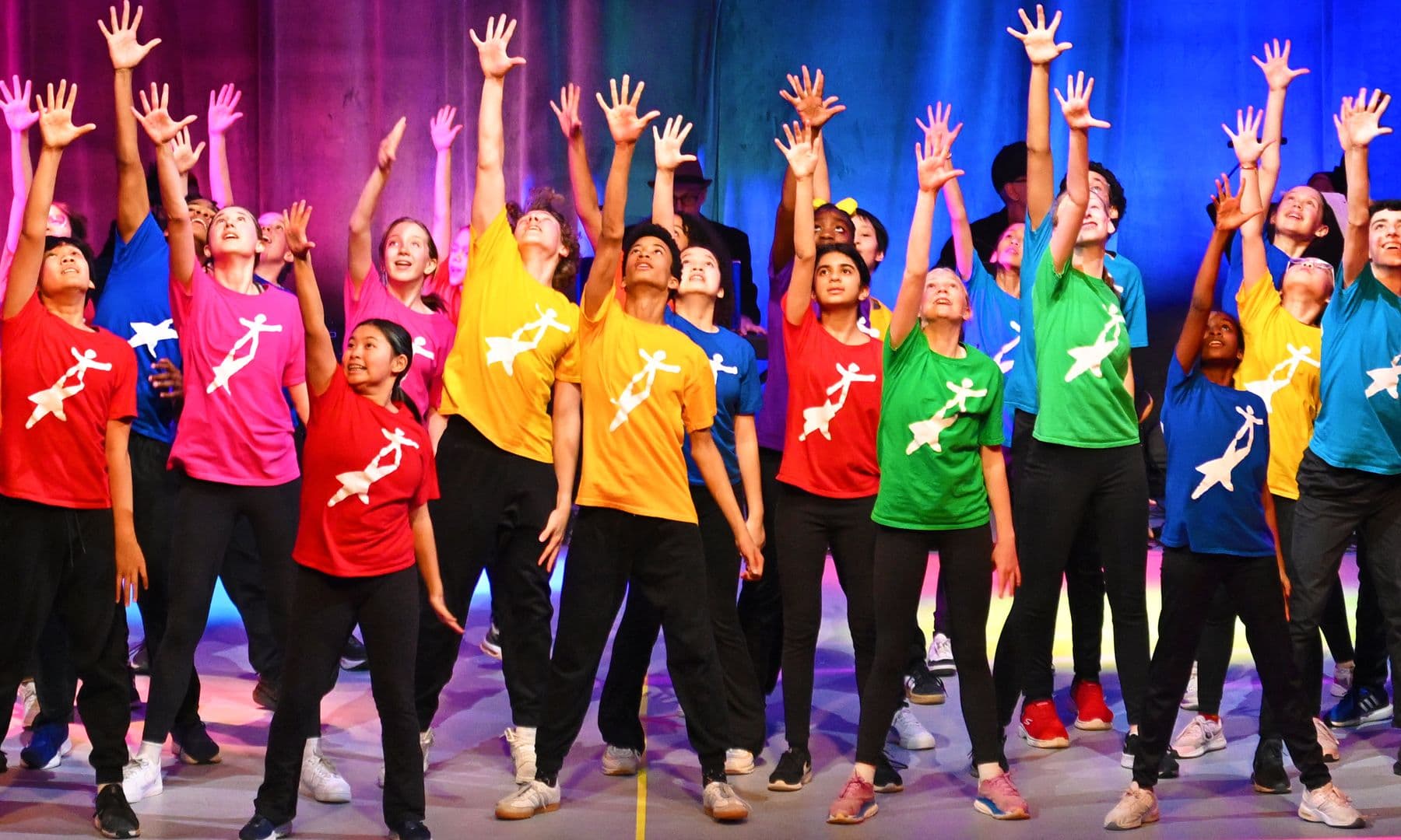 Donate today! Children with arms raised on stage at NDI's Gala in 2025