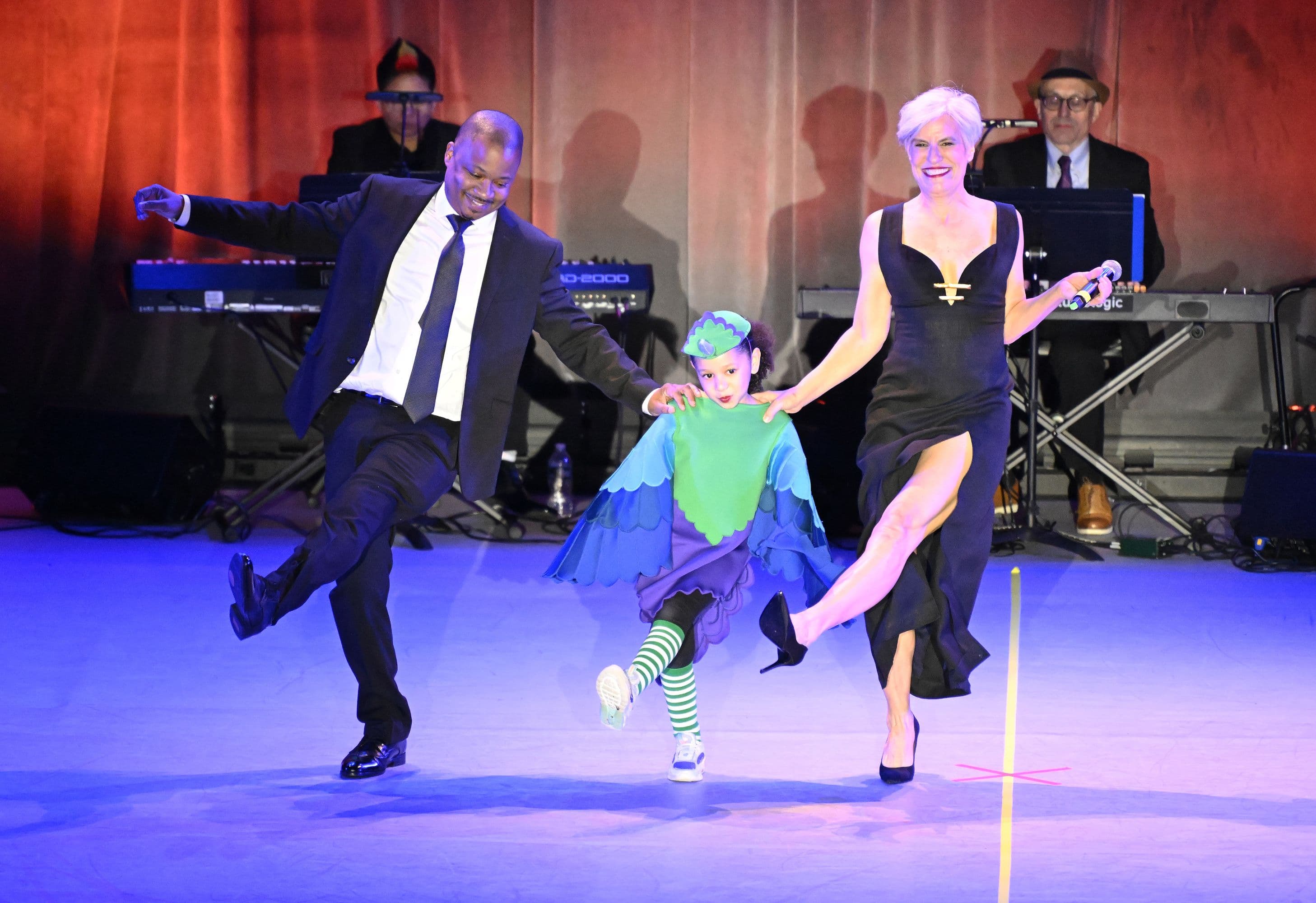 Jermaine Jones and Kay Gayner dance at an NDI Gala on stage with an NDI First Team dancer