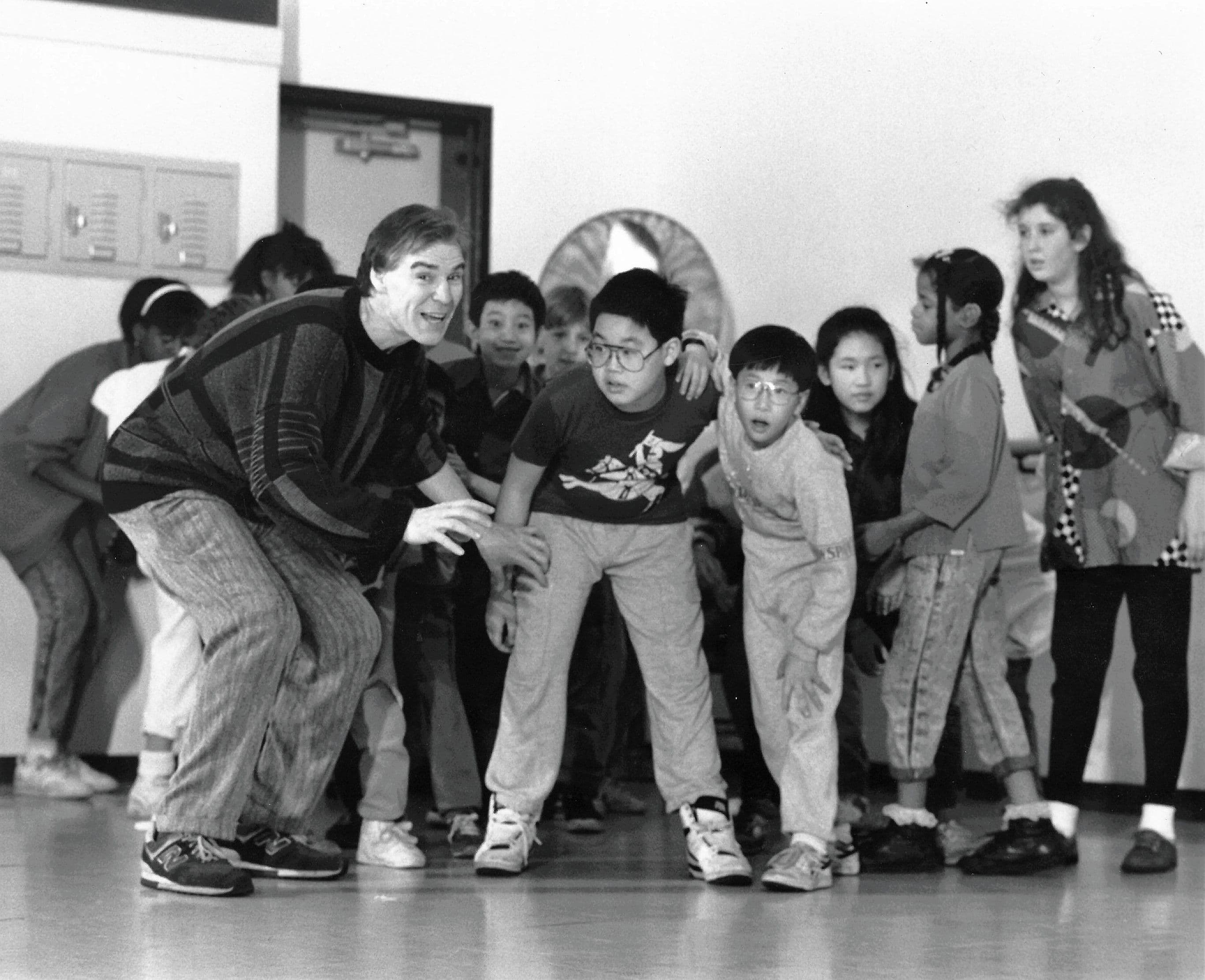 JdA_Teaching kids at school, crouching
